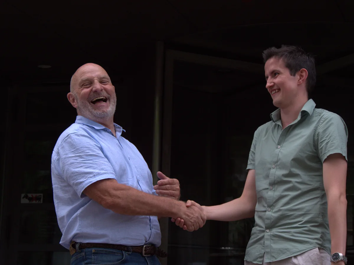 Man sieht zwei Männer, die sich die Hand schütteln.